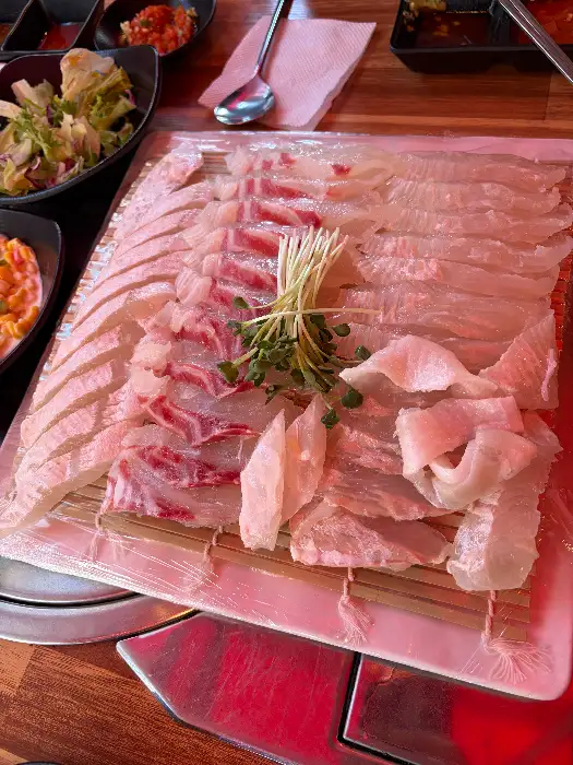 신선한 회 한 점과 곁들임 채소
