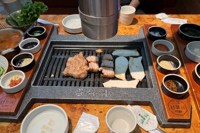 잘 구워진 삼겹살과 곁들임 반찬들