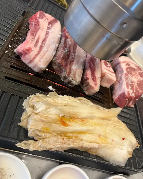지글지글 숯불 위에서 구워지는 흑돼지 오겹살과 백김치