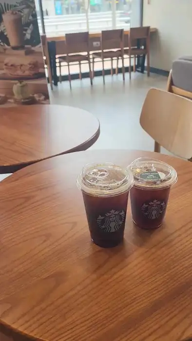 나무 테이블 위에 놓인 두 잔의 아이스 아메리카노