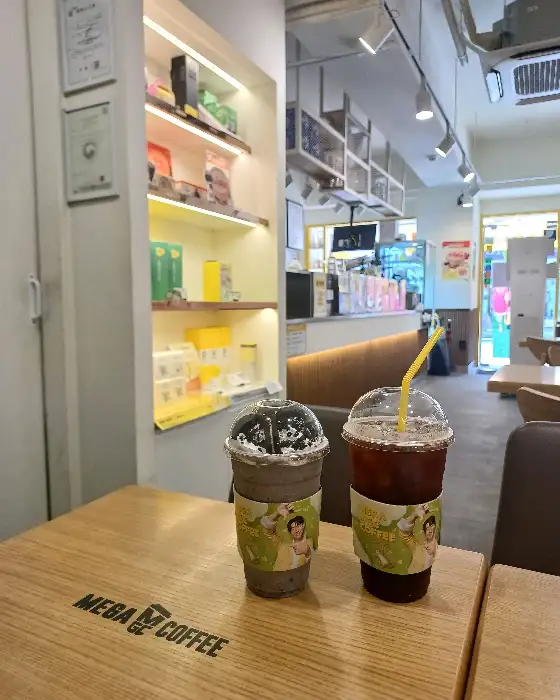 테이블 위에 놓인 두 잔의 음료. 하나는 얼음과 함께, 다른 하나는 컵 홀더에 담겨 있다.