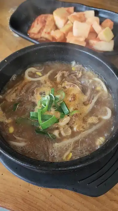 김이 나는 해장국에 파가 올라가 있는 모습