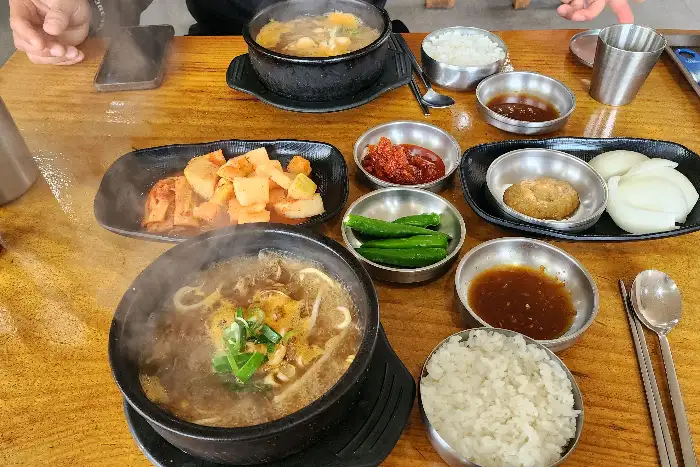 테이블에 여러 가지 해장국과 반찬들이 차려진 모습