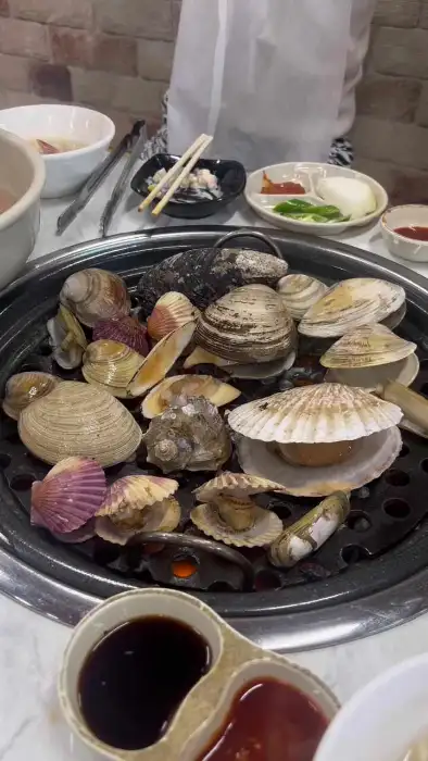 다양한 조개들이 불판 위에서 구워지고 있는 모습