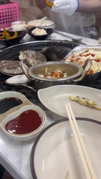 불판 위에 치즈 조개구이와 국물 요리