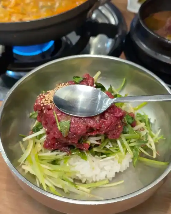 뭉티기 한 덩어리가 밥 위에 올려져 있는 모습