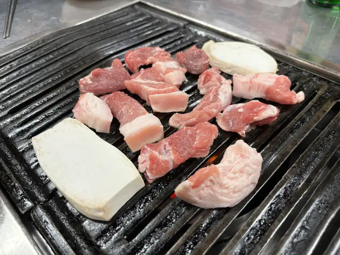 불판 위에서 구워지고 있는 다양한 부위의 고기