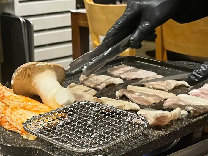 직원이 냉동 삼겹살을 굽는 모습
