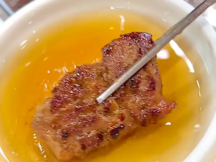 갈비 한 점을 소스에 찍는 모습