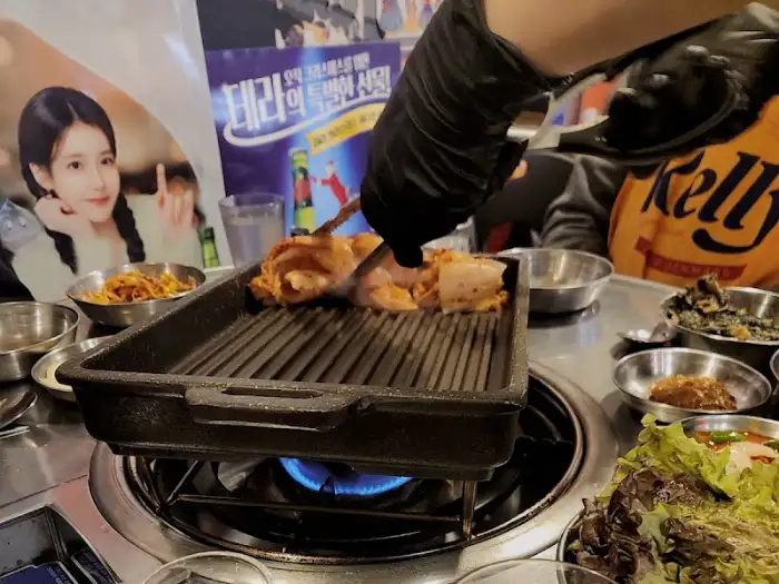 가위로 통삼겹살을 잘라주고 있는 모습입니다.