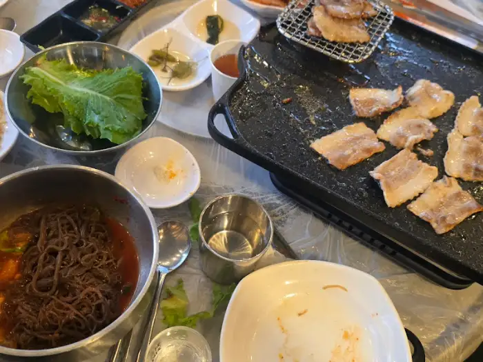 구워진 삼겹살과 곁들임 음식 모습
