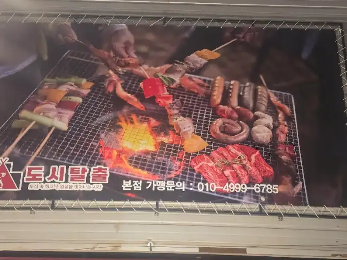 숯불 위에서 구워지고 있는 다양한 종류의 고기 꼬치와 통삼겹살