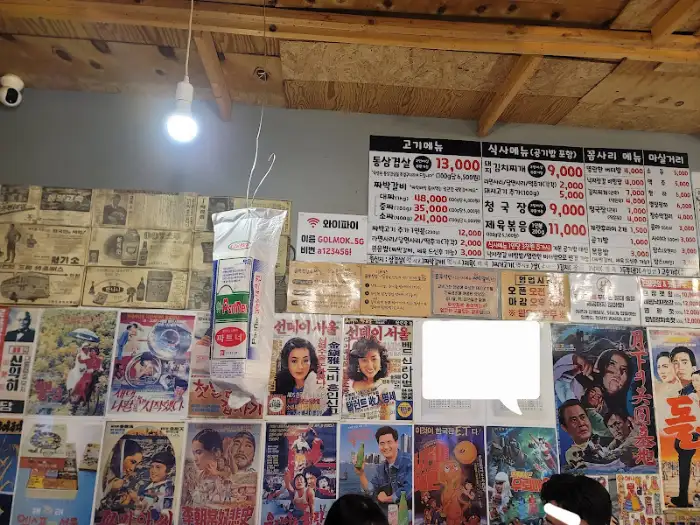 벽면 가득 붙어있는 포스터와 메뉴판이 보입니다.