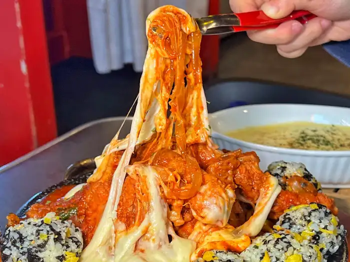 집게로 집어 올린 등갈비찜과 늘어나는 치즈