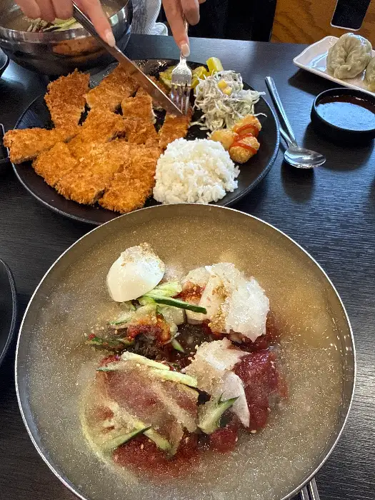 곱배기 사이즈의 냉면과 곁들임 메뉴