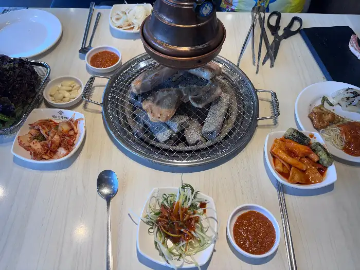 식탁에 차려진 다양한 반찬과 떡볶이, 샐러드