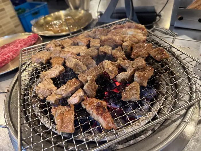 잘게 썰린 갈비 조각들이 숯불 위에서 익어가는 모습