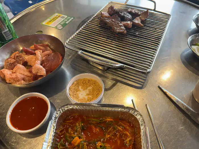 불판 위에서 익어가는 돼지 부속과 곁들임