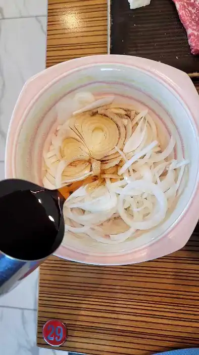 채 썬 양파에 소스를 뿌리는 모습