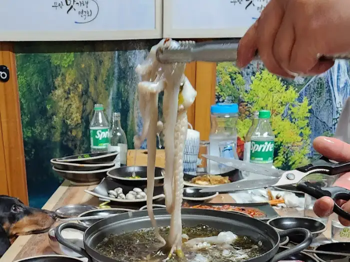 집게로 집어 올린 꿈틀대는 산낙지