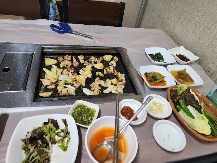 테이블 전체 상차림 모습, 구워지는 곱창과 여러 가지 반찬들