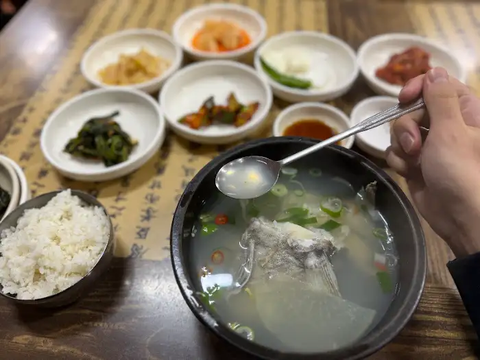 대구탕 국물을 떠서 맛보는 장면