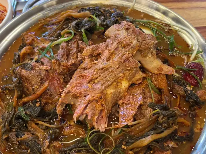 육수 속에서 부드럽게 익은 감자탕의 살코기와 시래기