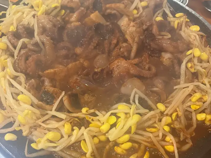 매콤한 쭈꾸미와 삼겹살, 콩나물이 함께 볶아지고 있는 모습