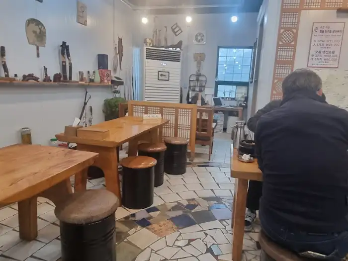 식당 내부의 테이블과 의자, 그리고 손님이 앉아 있는 모습