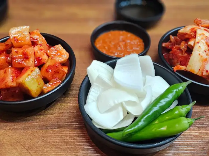 맛있어 보이는 깍두기와 마늘, 고추, 양파