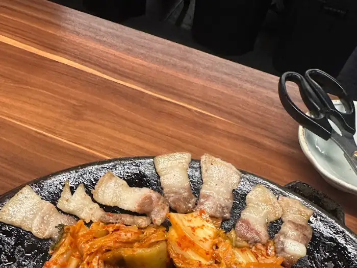 무쇠판 위에서 익어가고 있는 삼겹살과 김치