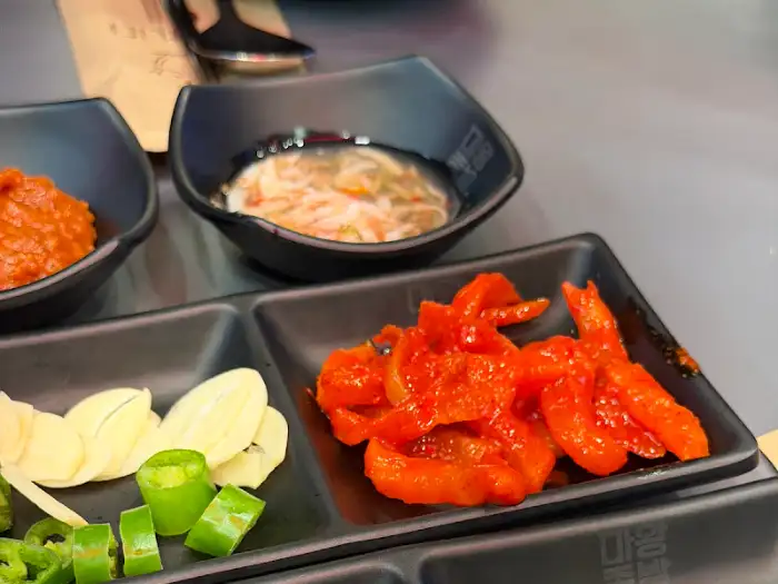매콤한 양념의 젓갈과 쌈 채소, 마늘 슬라이스