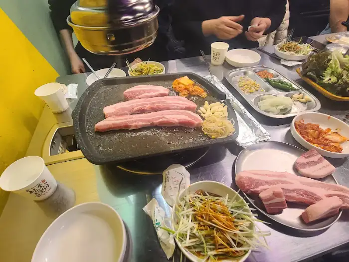 테이블에 차려진 삼겹살 구이와 반찬들