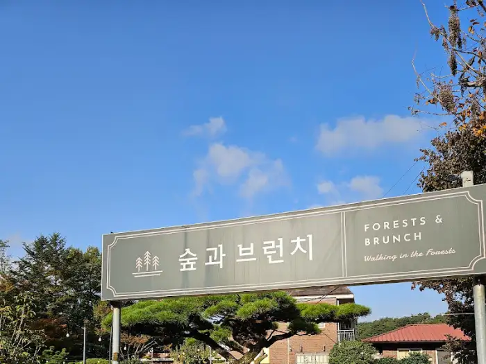 '숲과 브런치' 간판이 푸른 하늘 아래 걸려있다.