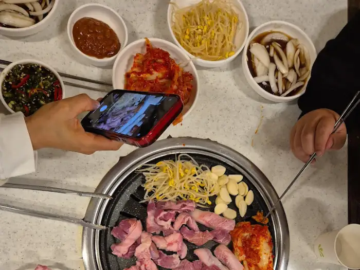 다양한 곁들임 찬과 고기가 올려진 불판