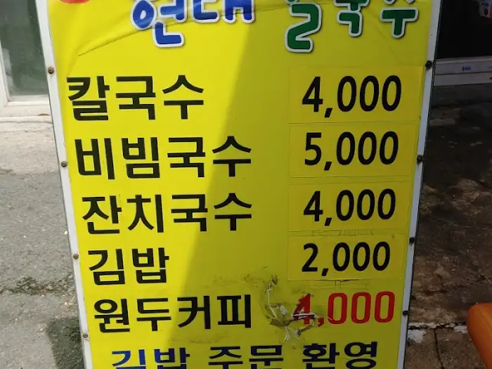 노란색 메뉴판에 칼국수, 비빔국수, 김밥 등의 가격이 적혀 있다.