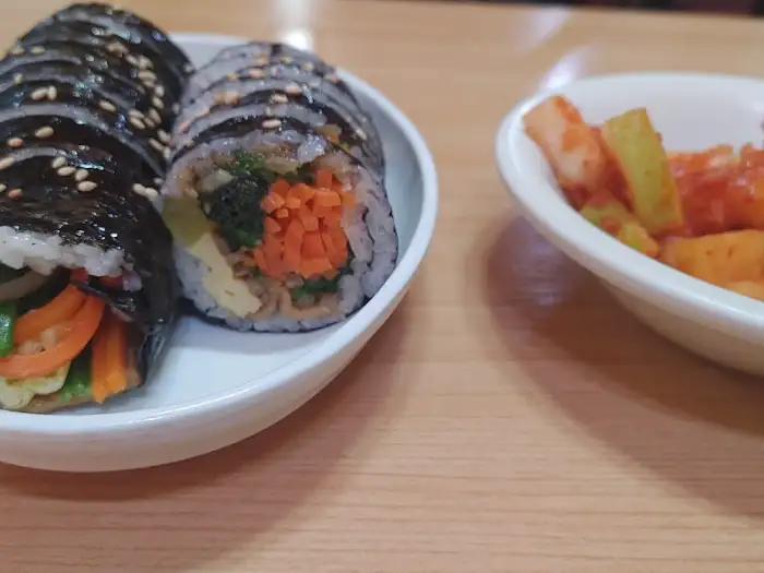 김밥 조각과 새콤해 보이는 김치가 담긴 접시