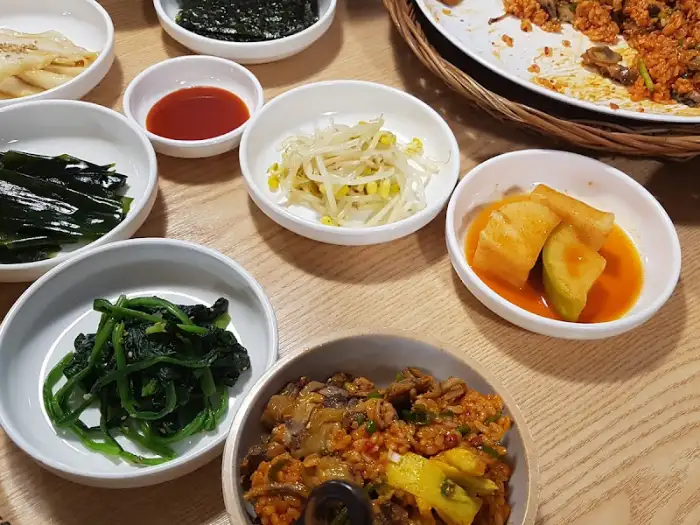 다양한 반찬과 꼬막 비빔밥의 모습