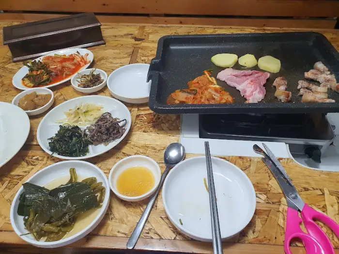 불판 위에서 익어가는 삼겹살과 김치