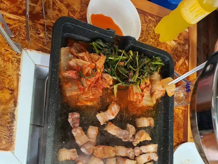 김치와 함께 익어가는 삼겹살 조각