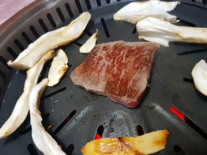 불판 위에 익어가는 한우 등심과 버섯