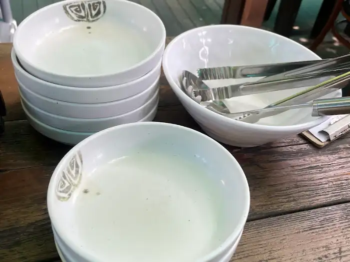 쌓여있는 흰색 그릇들과 집게가 담긴 볼