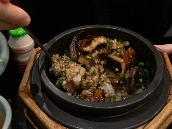 테이블에 차려진 솥밥과 다양한 반찬들, 정갈한 상차림을 보여줍니다.
