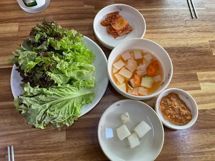 싱싱한 쌈 채소와 김치, 그리고 깍두기가 담긴 반찬 그릇