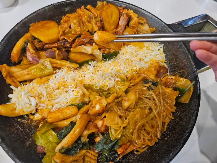 젓가락으로 닭갈비를 집어 올리는 모습