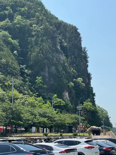 산자락 아래 자리 잡은 식당 풍경. 푸른 산이 배경으로 펼쳐져 있다.