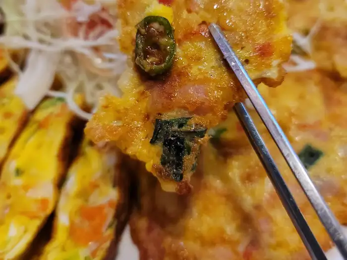 참치전 한 조각을 집는 젓가락