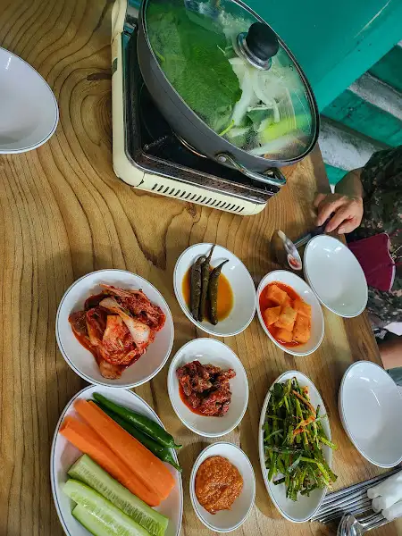 테이블 위에 차려진 다양한 밑반찬과 냄비