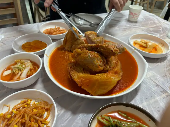 집게로 김치찜을 건져 올리는 모습
