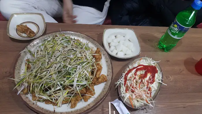샐러드와 닭강정, 그리고 음료가 함께 놓인 테이블